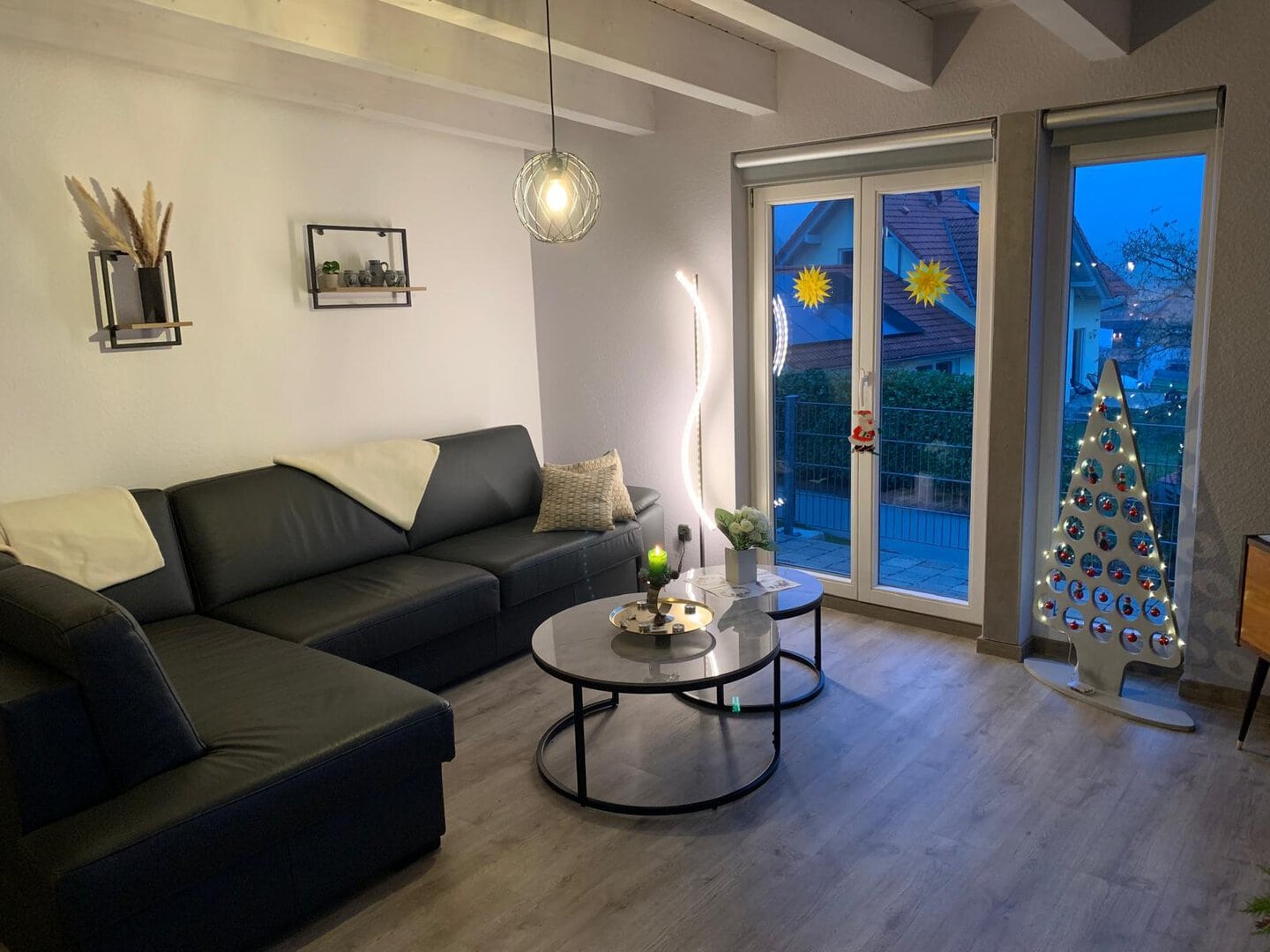 Modernes Wohnzimmer mit Sofa, Couchtisch und Balkonblick.